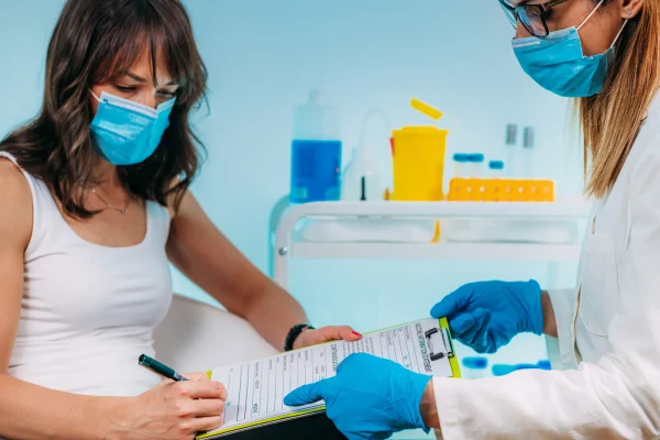 Mujer en consulta médica recibiendo información sobre rilutek para qué sirve y cómo este medicamento ayuda en el manejo de la esclerosis lateral amiotrófica bajo supervisión médica especializada